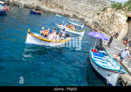 Les touristes de prendre un voyage à la Grotte Bleue dans de petits bateaux sur Malte. Banque D'Images