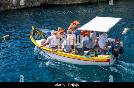 Les touristes de prendre un voyage à la Grotte Bleue dans de petits bateaux sur Malte. Banque D'Images