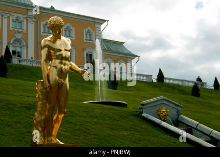 Statue dorée d'Antinoüs Capitolin contre pente gazonnée avec fontaine et Grand Peterhof Palace à Saint-Pétersbourg, Russie, 18e siècle landmarks Banque D'Images