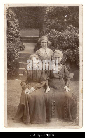 Début des années 1900 Carte postale édouardienne, 3 générations de femmes, posant pour une photo dans le jardin, vers 1905, au Royaume-Uni. Banque D'Images