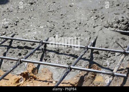 Mouiller le béton est coulé dans un treillis métallique en acier, Banque D'Images