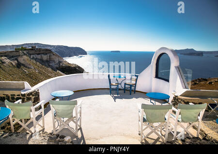 Des tables et des chaises sur le toit avec une vue romantique panorama sur l'île de Santorin, Grèce, sur la mer Egée. Banque D'Images