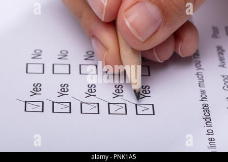 Close-up of a Woman's Hand cochant Oui choix sur le formulaire d'examen Banque D'Images