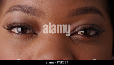 Close up of black female's beaux yeux looking at camera sur un écran vert Banque D'Images