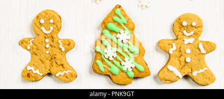 Gingerbread men amis de l'arbre de Noël sur une table en bois blanc Banque D'Images