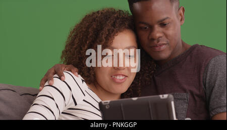Close-up of black couple flânant et à l'aide de tablette sur un écran vert Banque D'Images