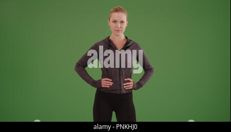 Woman standing with hands athlète à hanches sur écran vert Banque D'Images