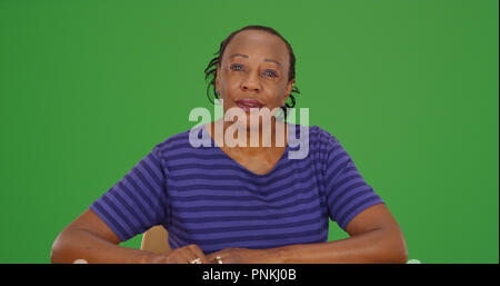 Habillé décontracté black woman looking at camera sur écran vert Banque D'Images