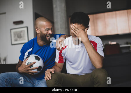 Amis regardant un match de foot Banque D'Images