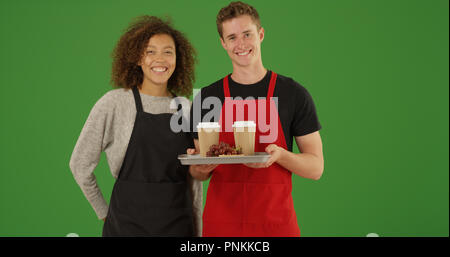Portrait de deux serveurs avec plateau de nourriture et boissons smiling sur écran vert Banque D'Images