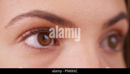 Close up de femmes les yeux de millénaire à offscreen sur écran vert Banque D'Images