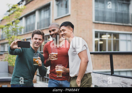 Groupe d'amis en tenant un bar extérieur en selfies Banque D'Images