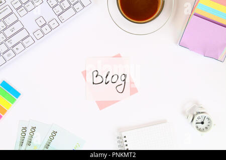 Blog de texte sur un autocollant note sur un bureau blanc à côté d'une tasse à café et d'un clavier. Vue de dessus, la mise en page Banque D'Images