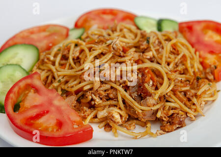 Le poulet, l'ail et le piment nouilles servies avec des tranches de concombre et de tomate. Banque D'Images