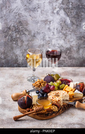 Assiette de fromage aux raisins, figues, trempettes et vin. Selective focus Banque D'Images