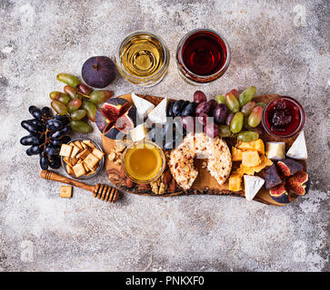 Assiette de fromage aux raisins, figues, trempettes et vin. Vue d'en haut Banque D'Images