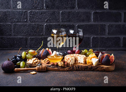 Assiette de fromage aux raisins, figues, trempettes et vin. Selective focus Banque D'Images