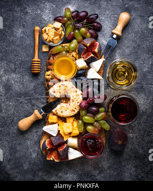 Assiette de fromage aux raisins, figues, trempettes et vin. Vue d'en haut Banque D'Images