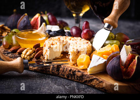 Assiette de fromage aux raisins, figues, trempettes et vin. Selective focus Banque D'Images