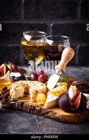 Assiette de fromage aux raisins, figues, trempettes et vin. Selective focus Banque D'Images
