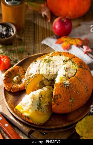 Dîner de dinde de Thanksgiving. Citrouille farcie au four avec la Turquie, le riz et les légumes sur fond rustique. Le concept de la nourriture sur l'action de grâce. Banque D'Images