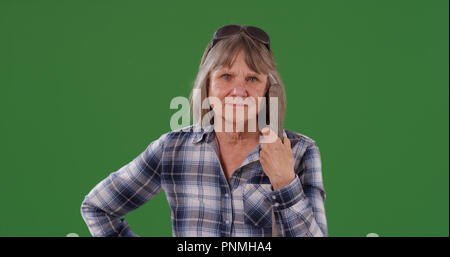 Young woman holding outil agricole debout sur un écran vert Banque D'Images