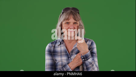 Personnes âgées farm woman standing avec manche de l'outil à la caméra sur l'écran vert à Banque D'Images