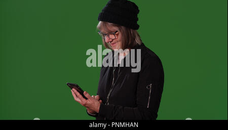 Des femmes âgées en utilisant smartphone pour envoyer un message sur l'écran vert Banque D'Images
