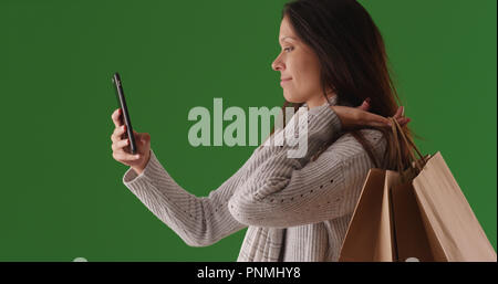 Portrait de profil de femmes prenant de l'acheteur avec selfies téléphone sur un écran vert Banque D'Images