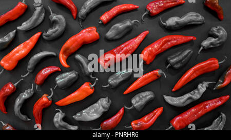 Rouge amour de la nourriture. Modèle photographique de poivrons rouges sur un fond sombre. Résumé Contexte les légumes. Vue d'en haut. Concept Rouge. Banque D'Images