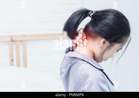 Femme Asiatique les maux de dos et s'asseoir sur le lit dans la chambre le matin.Le ton des couleurs Banque D'Images