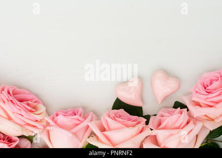 Rose fleurs fraîches frontière avec deux cœurs sur table lumineuse du dessus avec copie espace télévision, scène laïcs Banque D'Images