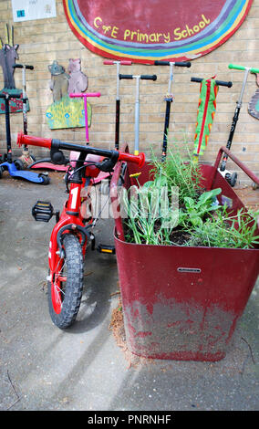 Vélo enfant rouge garée dans Jeux pour enfants avec des scooters à proximité. Banque D'Images