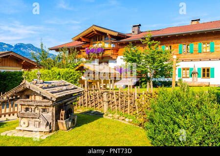 En bois typique maison alpine contre alpes contexte le pré vert à Going am Wilden Kaiser village aux beaux jours de l'été, Tyrol, Autriche Banque D'Images