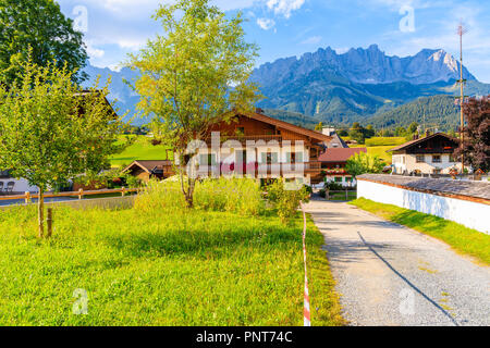 En bois typique maison alpine contre alpes contexte le pré vert à Going am Wilden Kaiser village aux beaux jours de l'été, Tyrol, Autriche Banque D'Images