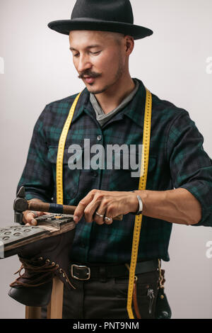 Cordonnier au studio. Méconnaissable shoemaker effectue chaussures dans le craft studio Banque D'Images