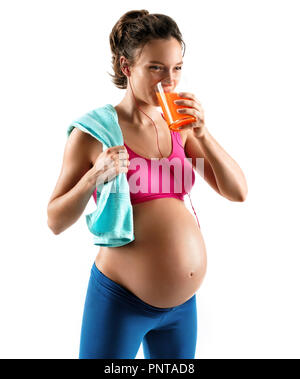 Temps de repos. Vêtements de femme enceinte en tenant une serviette et boire du jus isolé sur fond blanc. Concept de vie sain Banque D'Images