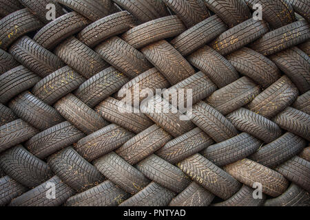 Contexte, la texture du mur de pneus mis à un angle. Caoutchouc de pneu noir, pièce du véhicule, pièce de rechange. Banque D'Images