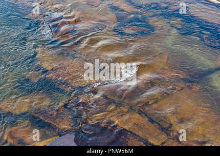 L'eau dans les eaux claires de la rivière qui coule sur les rochers, ce qui vous permet de voir en dessous pour les roches Banque D'Images