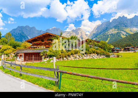 En bois typique maison alpine contre alpes contexte le pré vert à Going am Wilden Kaiser village aux beaux jours de l'été, Tyrol, Autriche Banque D'Images