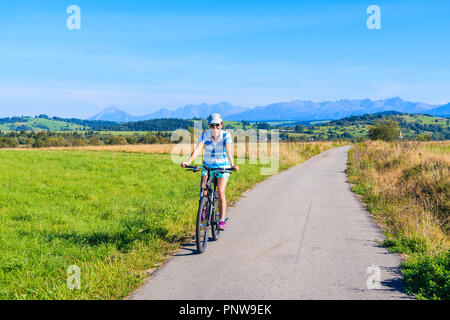 CZARNY DUNAJEC, POLOGNE - Sep 12, 2018 : young woman riding bike sur piste cyclable autour de Tatras près de Czarny Dunajec village. Le point final est i Banque D'Images