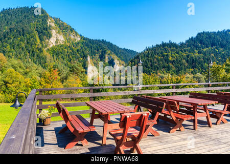 Tables rondes sur la terrasse du refuge de montagne dans les montagnes Pieniny par beau jour d'automne, Pologne Banque D'Images