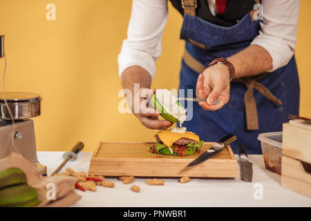 Faire cuire la préparation en ajoutant la sauce burger sur green bun. Banque D'Images