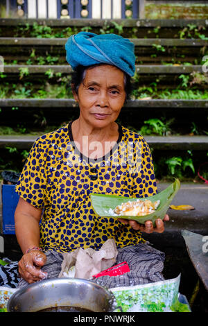 Une vieille dame la préparation de bonbons à un marché à Bali, Indonésie Banque D'Images