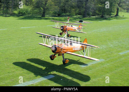 Breitling Wingwalkers Aerosuperbatics Boeing Stearman avions décollant de Henham Park piste en herbe en campagne du Suffolk. L'été britannique Banque D'Images