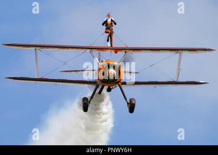 Aerosuperbatie Breitling Wintwalkers Boeing Stearman avion. Femme Stella Guilding aile marchant. Ciel bleu Banque D'Images