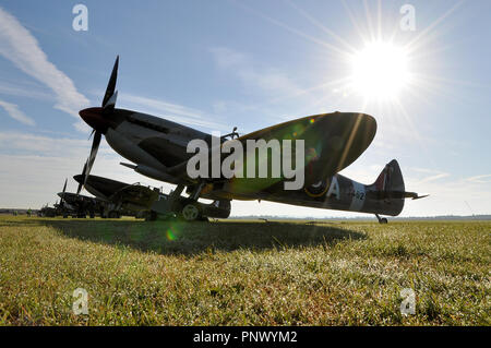 Spitfire Supermarine tôt le matin, un jour d'été ensoleillé avec le soleil se brûlant derrière. Avion de chasse de la Seconde Guerre mondiale. Rosée sur le sol Banque D'Images