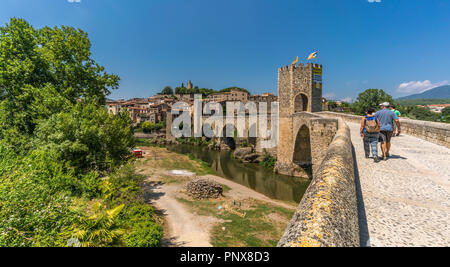 Besalu, Catalogne, Espagne - le 29 juillet 2018 : vue panoramique de touristes marcher le long pont roman sur la rivière Fluvia à Besalu, célèbre cité médiévale Banque D'Images