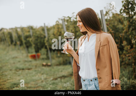 Dégustation de vin rouge vin femme à partir d'un verre dans un vignoble Banque D'Images