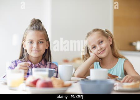 Deux jolies filles mignonnes vous regarde pendant que j'étais assis à table et le petit-déjeuner à l'accueil Banque D'Images